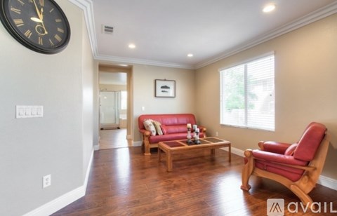 A living room with a red couch and a wooden coffee table.