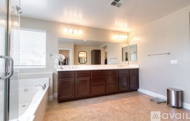 A bathroom with a large mirror and a bathtub.