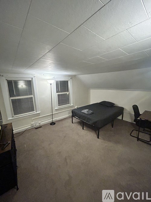 A room with a bed, chair, and table.