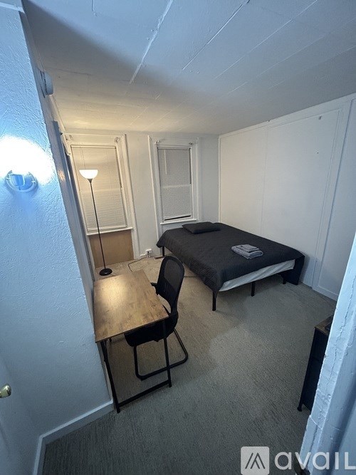 A small room with a bed, chair, and desk.