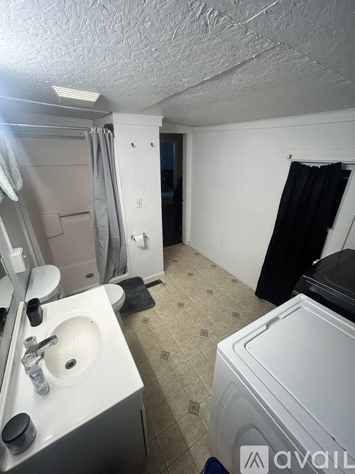A bathroom with a white sink and a washer and dryer.
