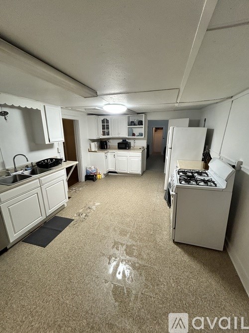 A kitchen with a white stove and white cabinets.
