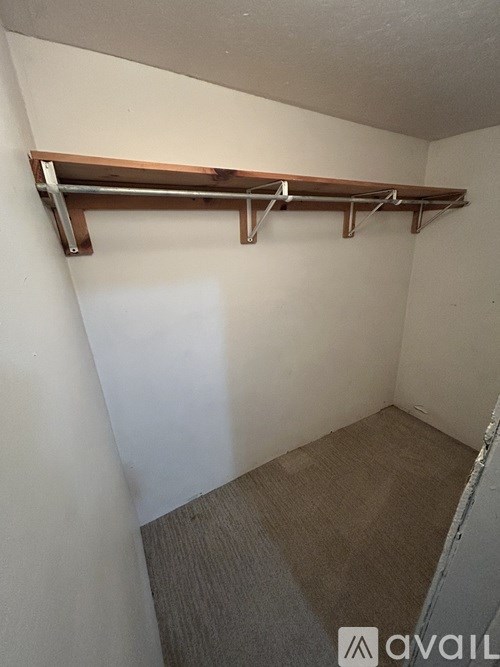 A small room with a shelf and a carpeted floor.