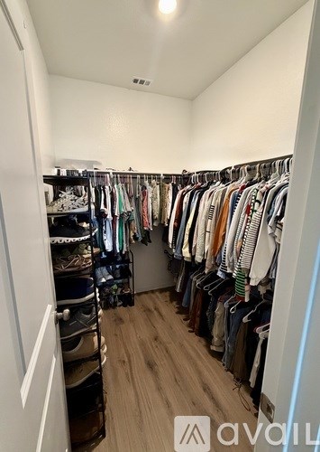 A walk-in closet with clothes and shoes.