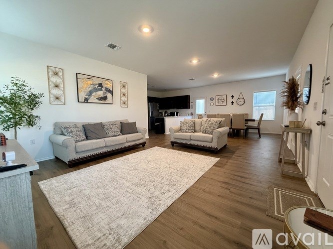 A living room with two couches and a rug in the middle.