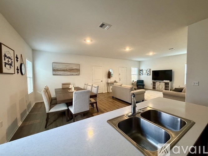 A kitchen with a sink and a dining table with chairs.