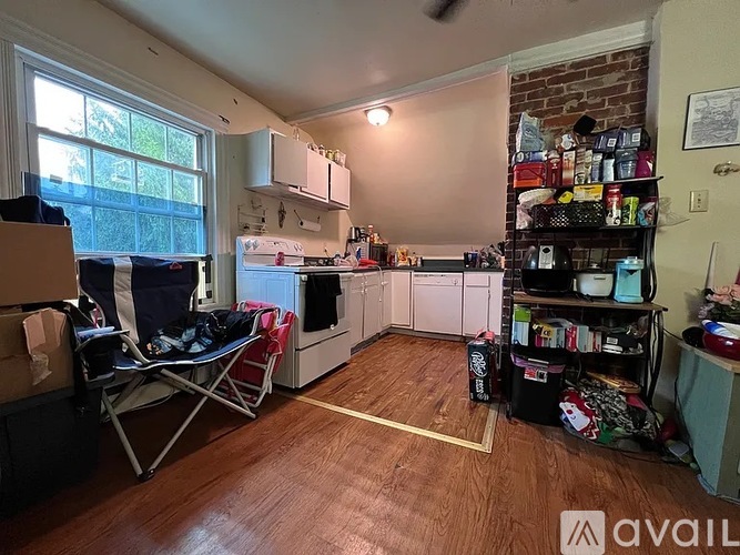 A kitchen with a white refrigerator and wooden floors.