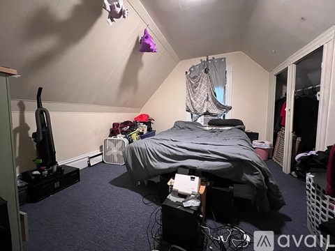A room with a bed, a fan, and a PlayStation.