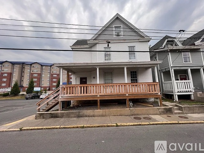 A house with a porch and a car parked in front.