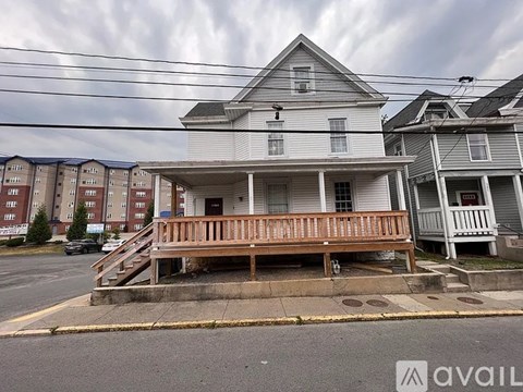 A house with a porch and a car parked in front.