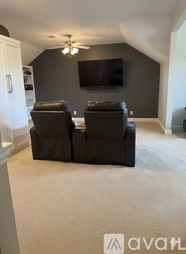 A living room with a television and two chairs.