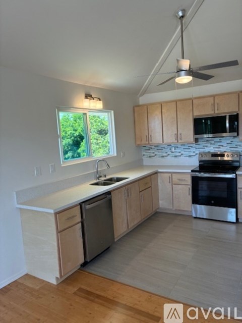 A kitchen with wooden cabinets and a window.
