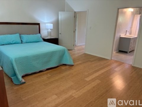 A bedroom with a bed and a bathroom visible through the door.