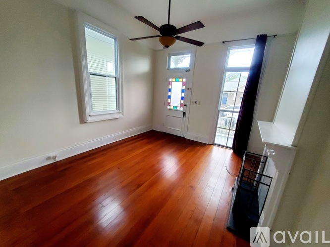 A room with wooden floors and a ceiling fan.