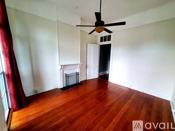A room with a fireplace and a fan.