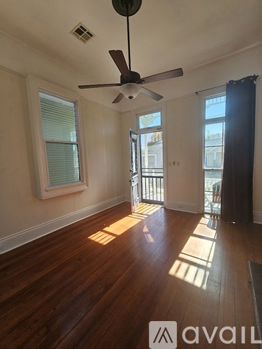 A room with wooden floors and a ceiling fan.