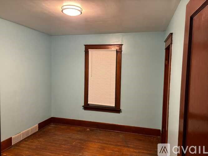 A room with a window and wooden floors.