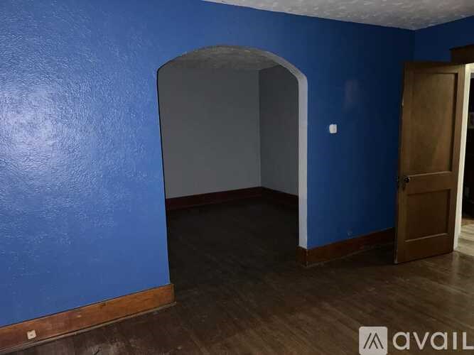 A room with blue walls and a wooden floor.