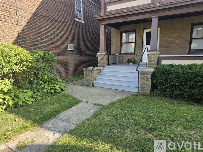 A brick house with a white door and steps leading to the entrance.