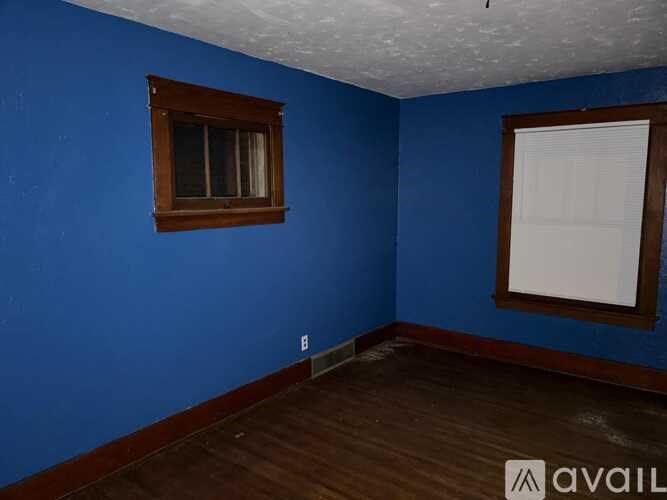 A room with blue walls and a window with a white curtain.