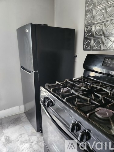 A black stove and fridge in a kitchen.