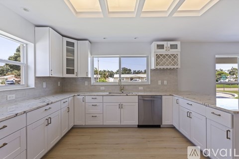 A kitchen with white cabinets and a large island.