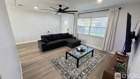 A living room with a black sofa and a glass coffee table.