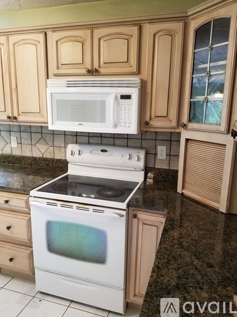 A kitchen with a white oven and microwave above it.