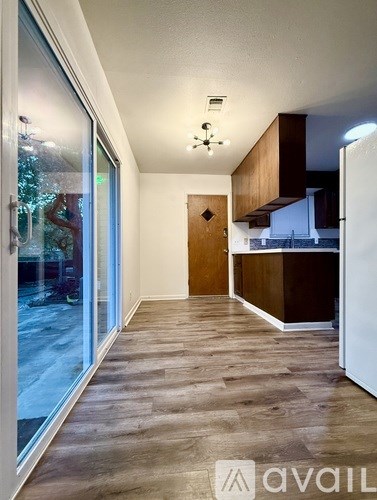 A kitchen area with a white refrigerator and wooden cabinets.