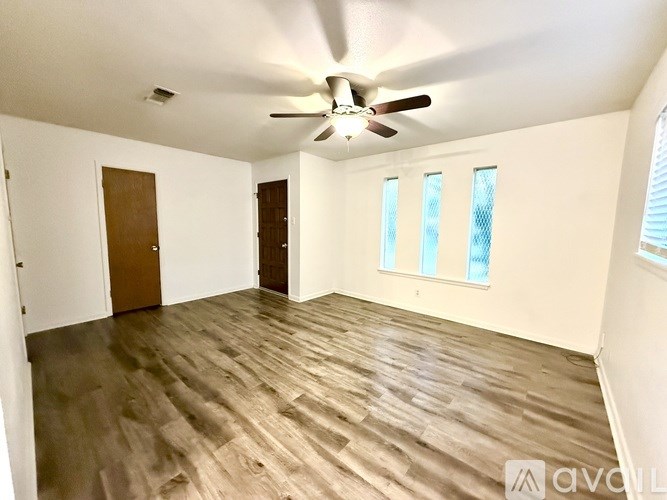 A room with wooden flooring and a ceiling fan.