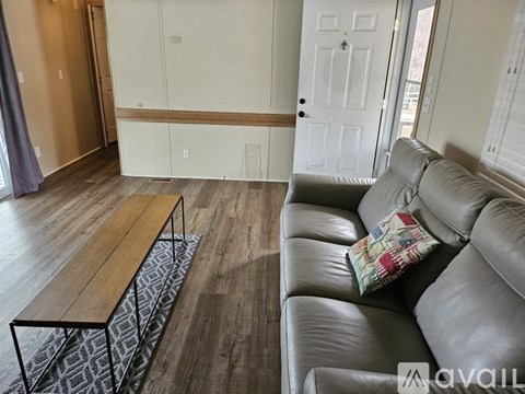 A living room with a grey couch and a wooden table.
