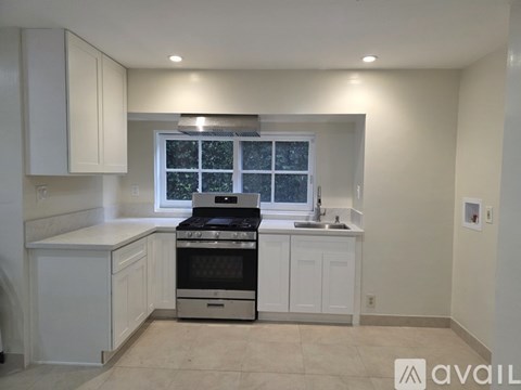 A kitchen with white cabinets and a stove top oven.