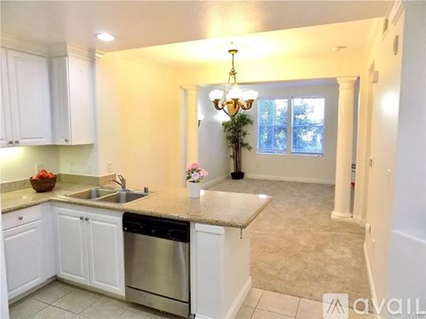 A kitchen with white cabinets and a granite countertop.