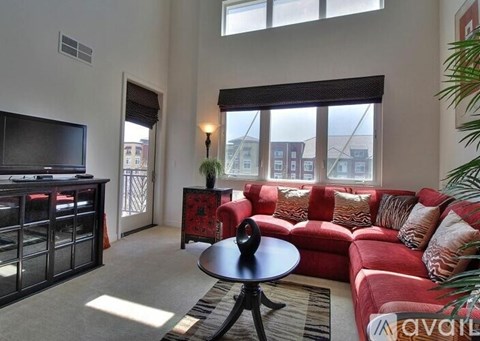 A living room with a red couch and a television.