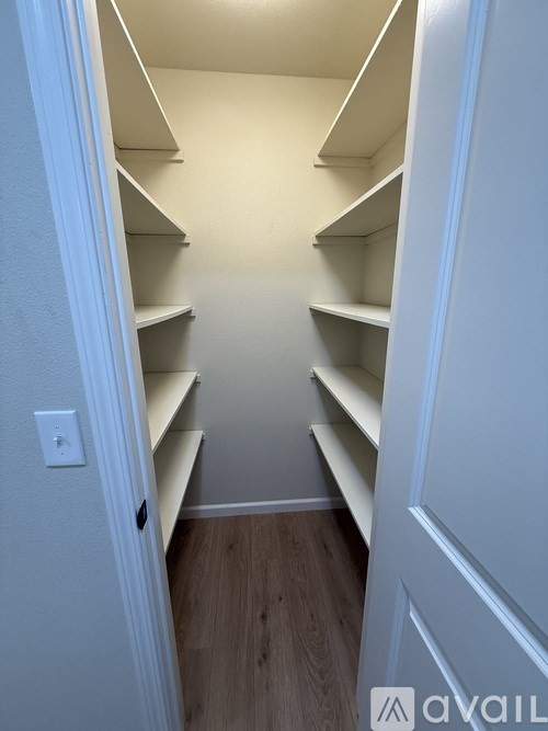 A white pantry with a light switch on the wall.