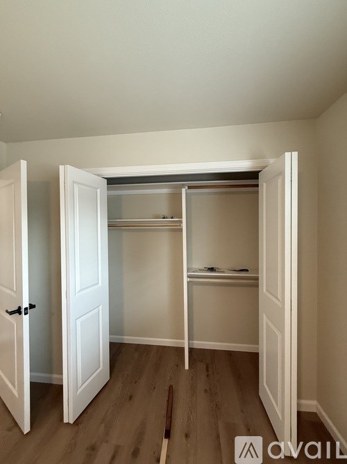 A white closet with a sliding door is open.