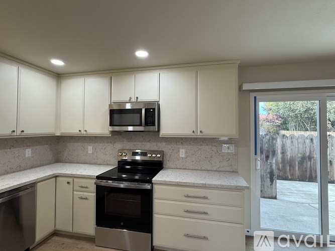 A kitchen with white cabinets and a black stove top oven.