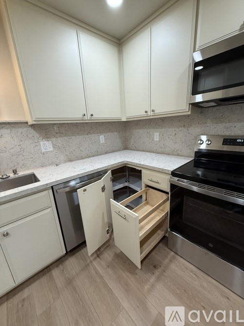 A kitchen with white cabinets and a black oven.