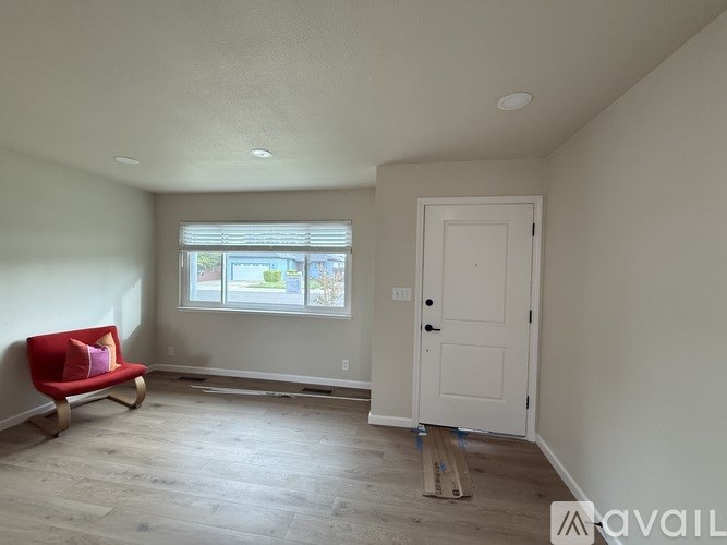 A room with a red chair and a white door.