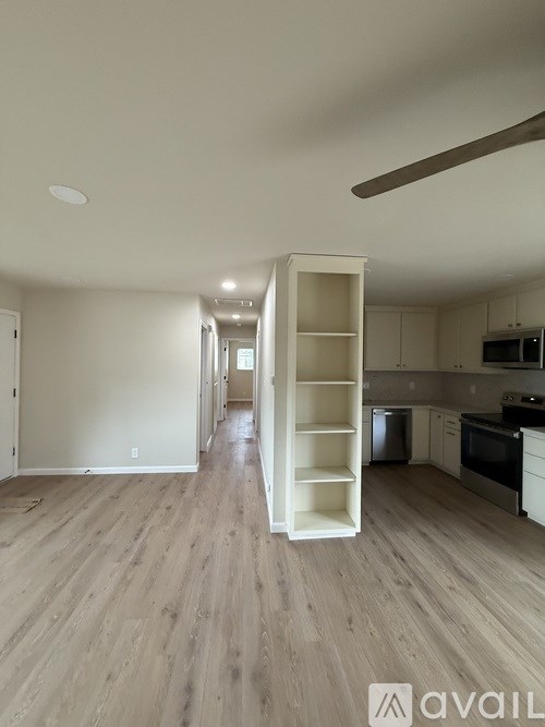 A kitchen with a white cabinet and a white open shelf.
