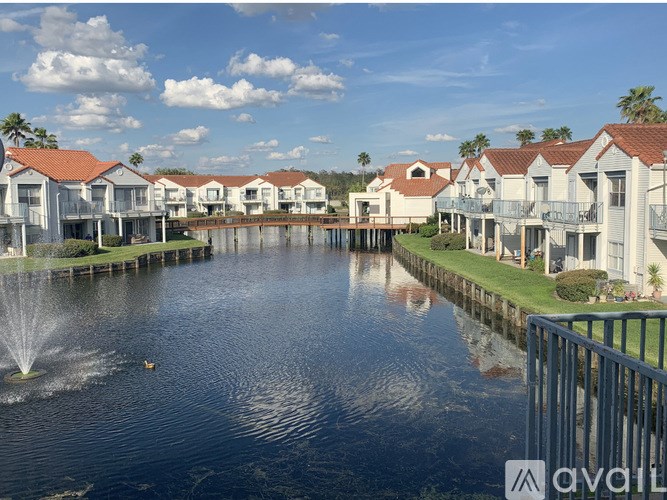 A row of houses with a fountain in the middle of a lake.