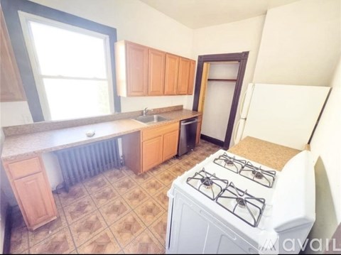 A kitchen with a white gas stove and wooden cabinets.