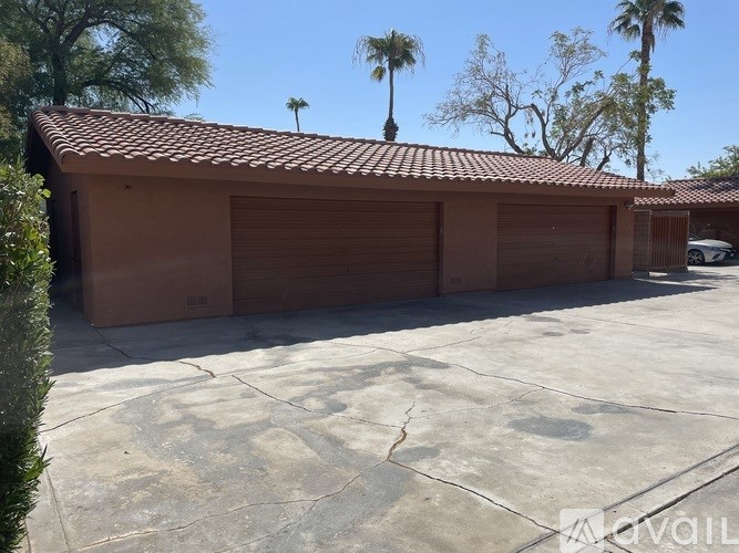 A two-car garage with a tiled roof and closed brown doors.
