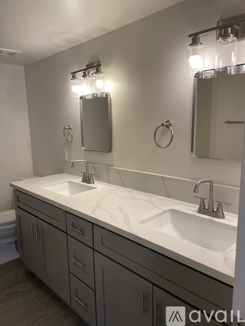A bathroom with two sinks and a large mirror.