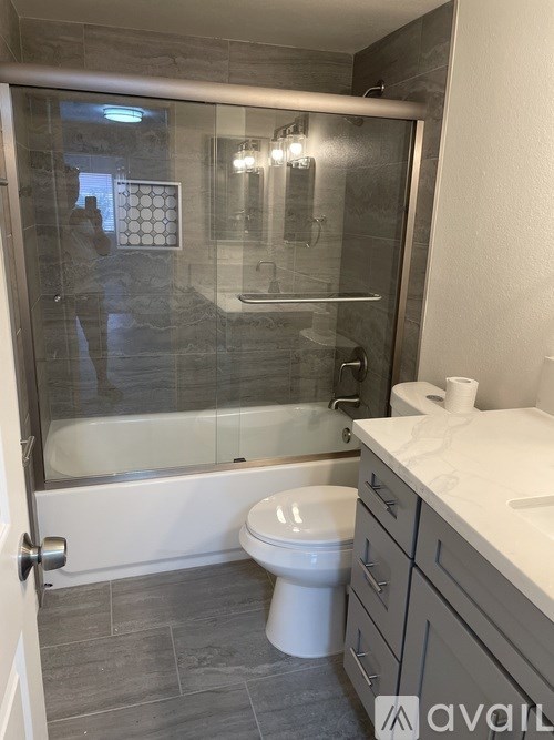 A bathroom with a toilet, sink, and shower.