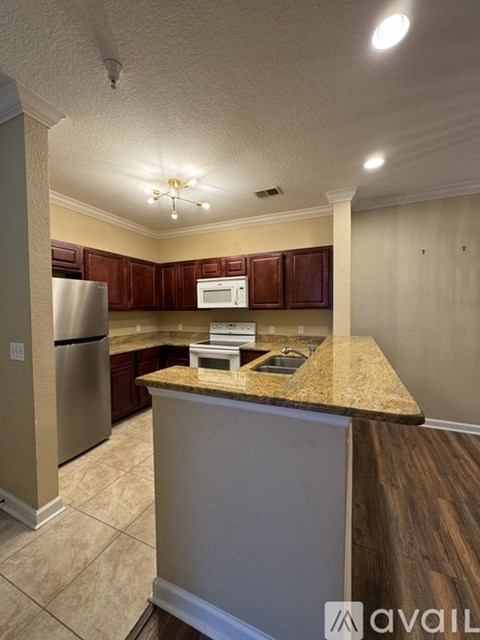 A kitchen with a granite countertop and stainless steel appliances.