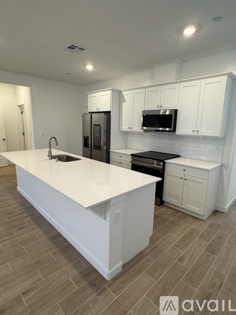 A kitchen with white cabinets and a white island.