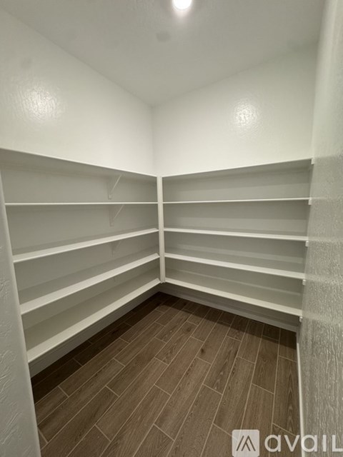 Empty white shelves in a room with wooden flooring.