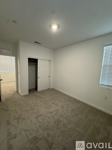 A room with a carpeted floor and a door leading to another room.