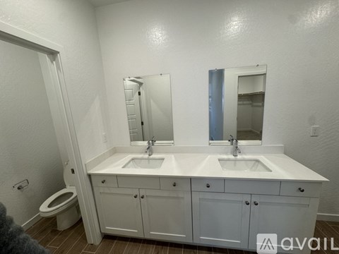 A bathroom with two sinks and a toilet.